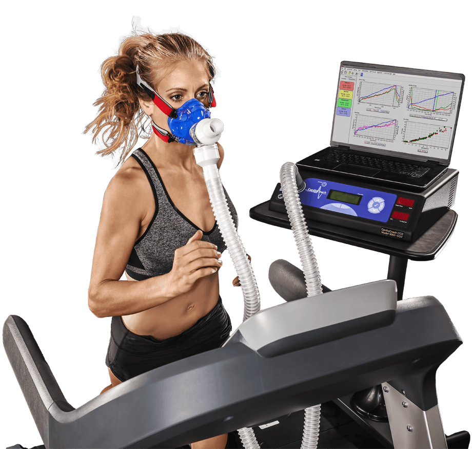 woman running on treadmill wearing vo2 mask with results on a laptop next to her